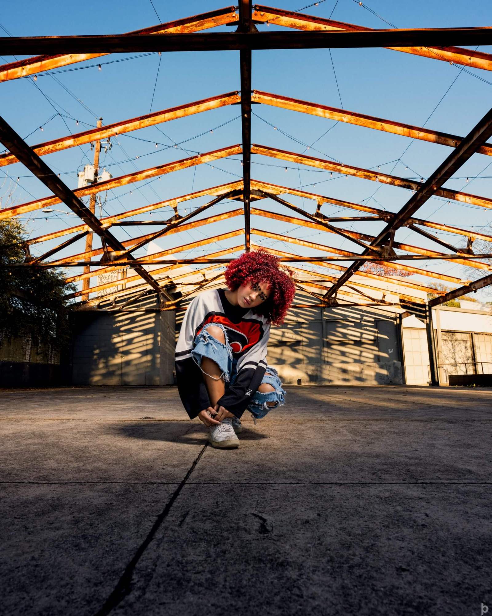 Artist styled in a rusted warehouse for a music campaign