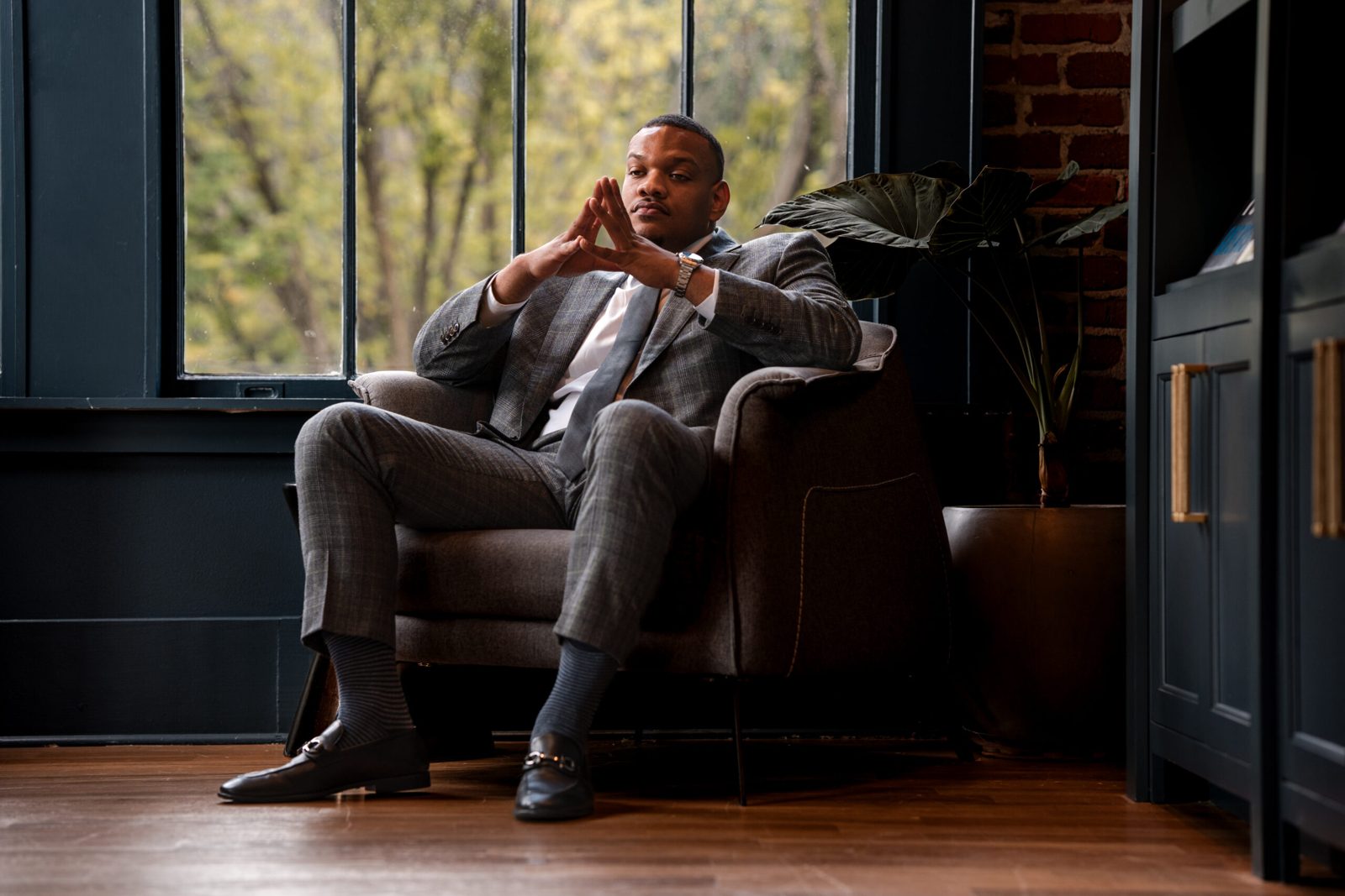 Attorney seated by a tall window in a dark-paneled office