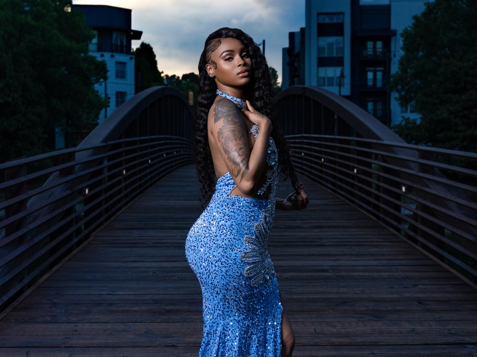 Portrait in a blue sequin gown on a lit Atlanta bridge at night